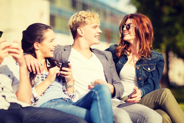 onderwijs, technologie, internet, zomervakantie, sociale netwerken en tienerconcept - groep tieners met smartphones