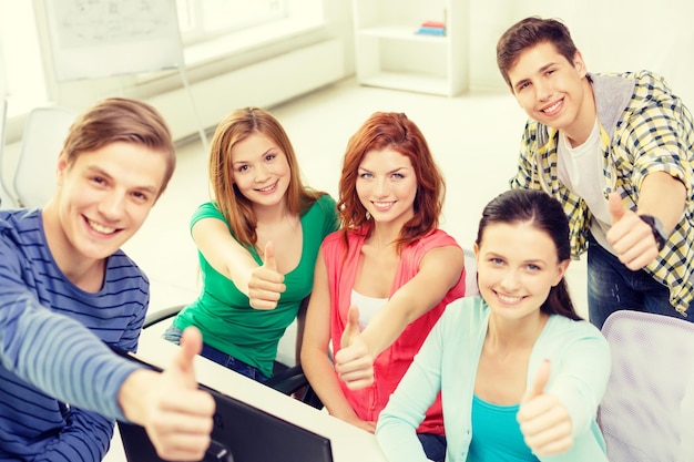 onderwijs, technologie, school en mensenconcept - groep glimlachende studenten die duimen opdagen in de computerklas op school