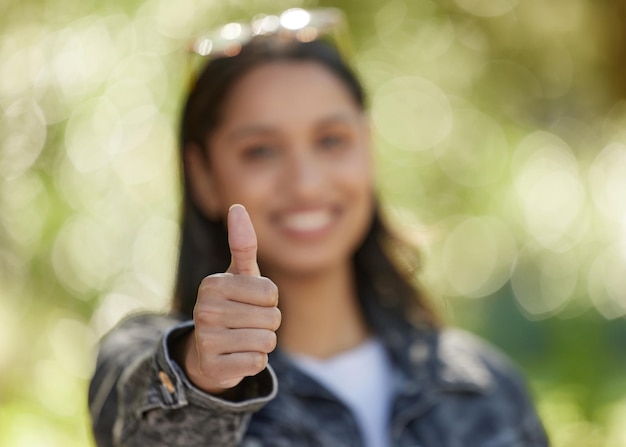 Foto onderwijs voor de overwinning shot van een jonge vrouw die haar duimen opsteekt terwijl ze buiten staat