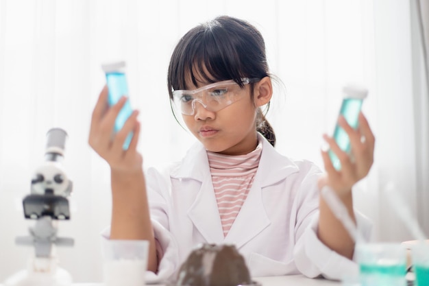 Onderwijs wetenschap scheikunde en kinderen concept kinderen of studenten met reageerbuis maken experiment op school laboratorium