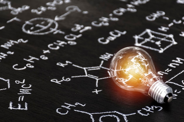 Foto onderwijssuccesconcept een schoolbord met een geschreven wiskundige formule en een gloeilamp erop