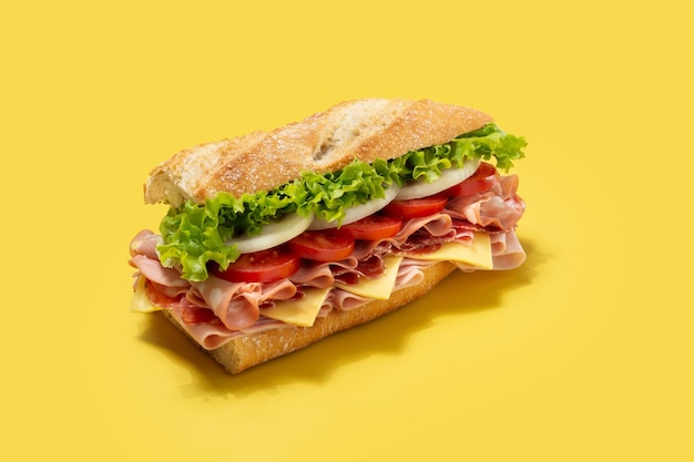 Onderzeese sandwich met ham, kaas, sla, tomaten, mortadella, en worst op gele achtergrond