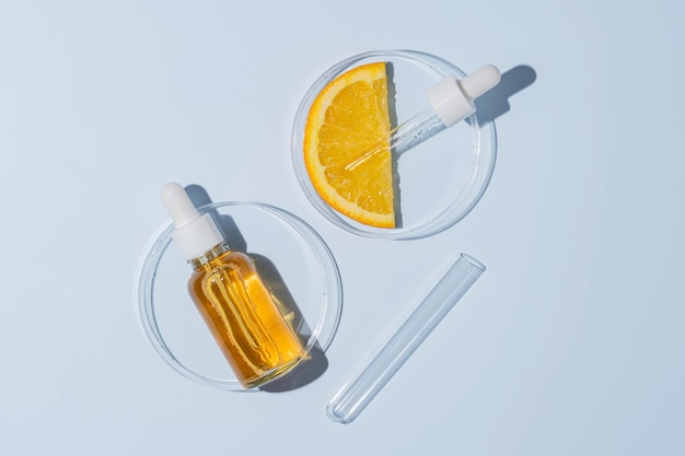 Onderzoek in citruslaboratoria, productie van cosmetica, extractie van AHA-componenten, huidverzorgingscosmetologie, testen van petriplaten met gezichtsserum en een stukje sinaasappel naast de testbuis.
