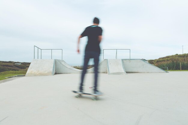 Onduidelijk beeld van een man die in het park skateboardt