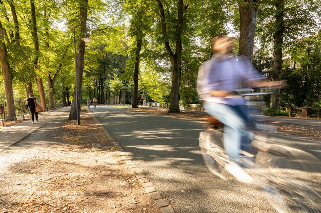 Foto onduidelijke beweging van een man die op de weg op de fiets rijdt