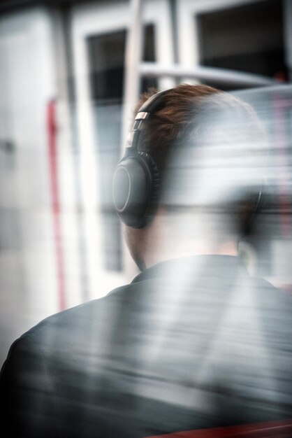 Foto onduidelijke beweging van jonge man die muziek luistert in de trein