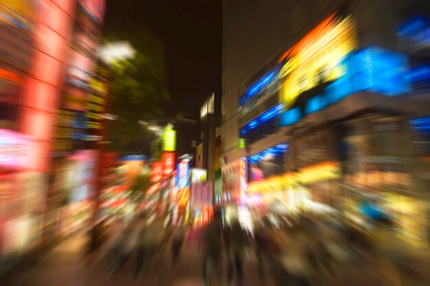 Foto onduidelijke bewegingen van mensen in een verlichte stad's nachts