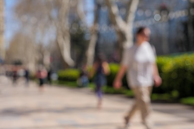 Onduidelijke foto van mensen die op een zonnige dag op trottoirs lopen