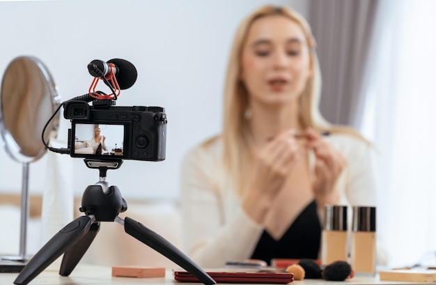 Onduidelijke jonge vrouw maakt schoonheid en cosmetische tutorial video inhoud voor sociale media Gefocuste camera scherm met schoonheid influencer laten zien hoe schoonheidszorg toe te passen op publiek of volgers Blithe