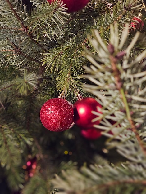 Onduidelijke kerstversieringen sieren een nieuwjaarsboom met flikkerende lichten en kleurrijke ornamenten.