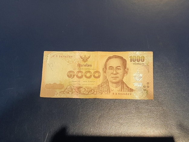 One 1000 Baht note on a black background Baht is the state currency of Thailand