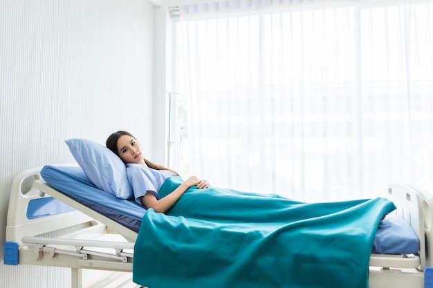 One asian young female patient With anxiety face lying on bed in the room hospital.