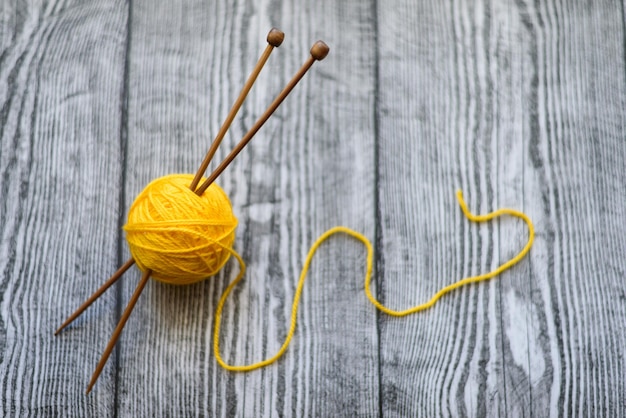 One ball of wool knitting needles on thewooden background