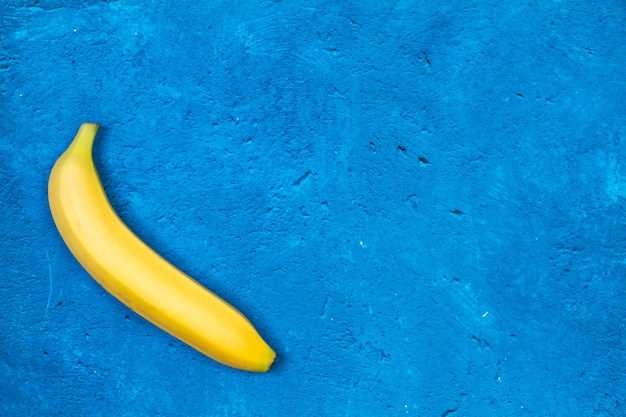 One banana on a textured classic blue background