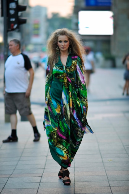 One beautiful young elegant woman in fashion and urban style\
dress in city on street at night alone