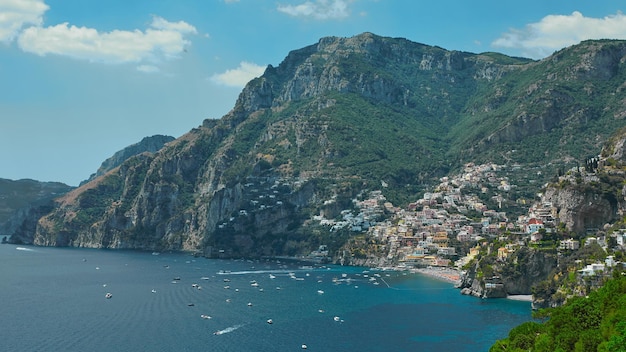 One of the best resorts of Italy with old colorful villas on the steep slope nice beach numerous yachts and boats in harbor and medieval towers along the coast Positano