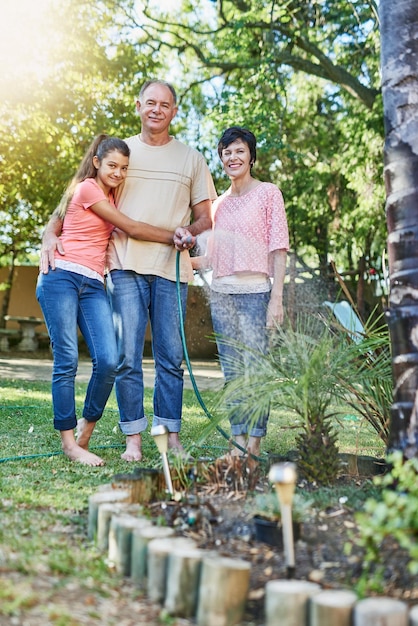 One big happy family Portrait of a family watering a garden with a hose