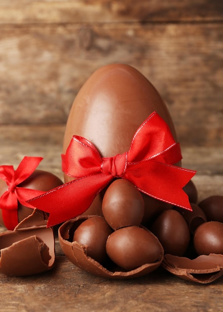 One big and small chocolate Easter eggs on wooden background