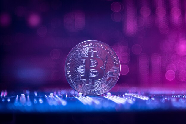 One bitcoin on the background of microboards. neon magenta. close-up