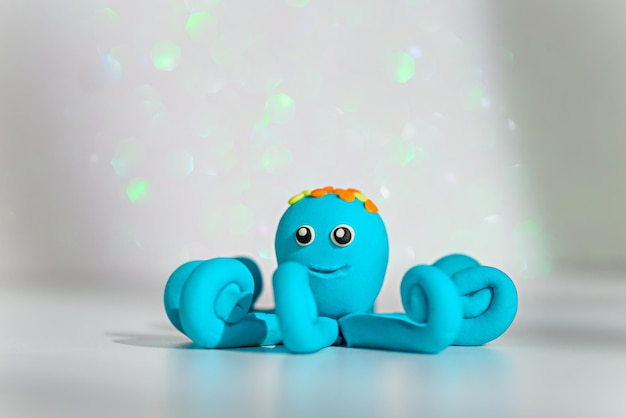 One blue plasticine octopus on shimmering shiny background children's games with modeling clay plasticine figures