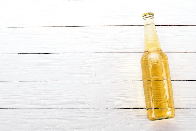 Foto una bottiglia di birra su uno sfondo di legno spazio libero per il testo vista dall'alto