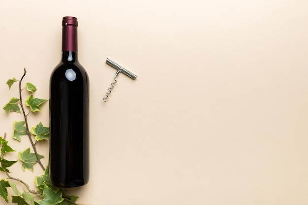 One Bottle of red wine with corkscrew on colored table Flat lay top view wth copy space