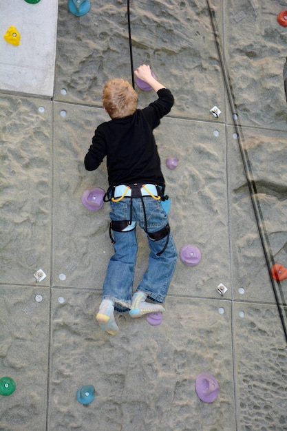 One boy climbs on a wall