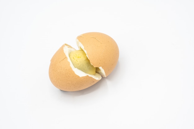 one brown egg and cracked on white background