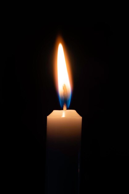 Photo one candle burning brightly on a solid black background