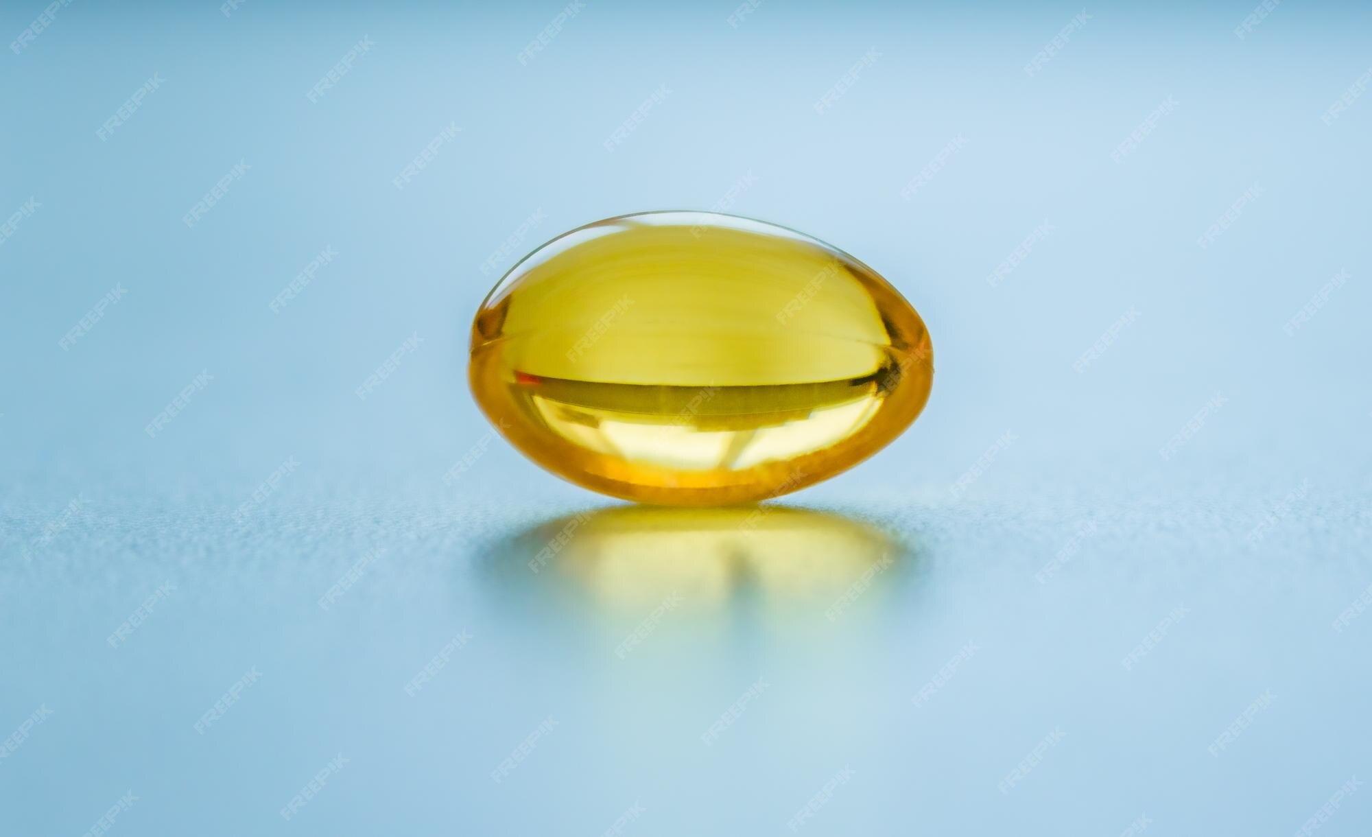 Premium Photo | One capsule of fish oil on a blue background