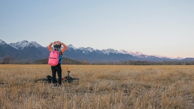 One caucasian children walk with bike in wheat field little girl walking black orange cycle on