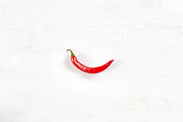 One chili hot pepper clipping path. Fresh red pepper. Chili pepper on white wooden background