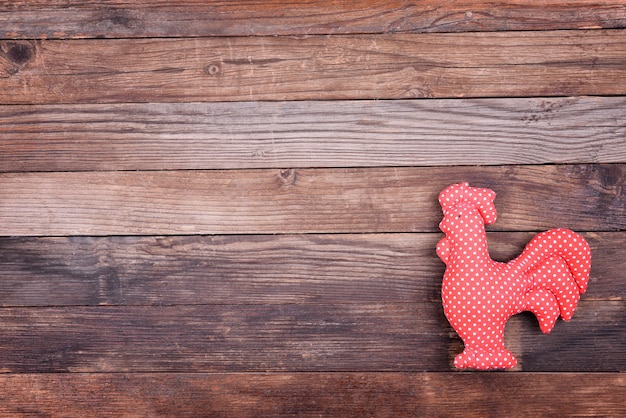 One Cock on wooden brown background