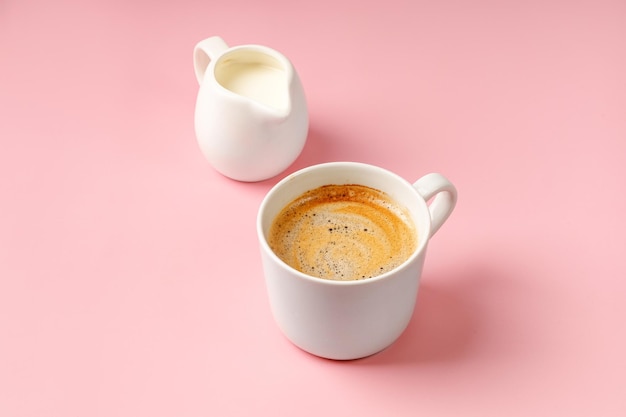 One coffee cup with Cappuccino and milk on pink background Espresso drink with foam Copy space