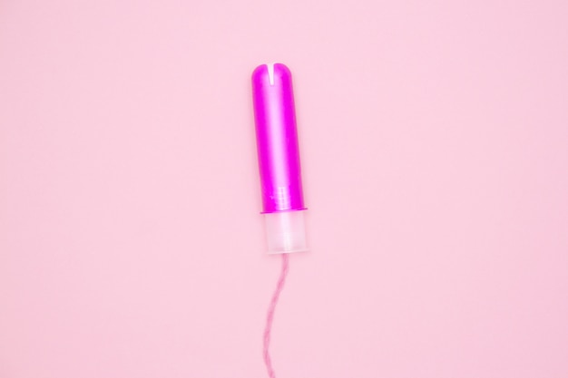 One cotton tampon with purple applicartor on pink 