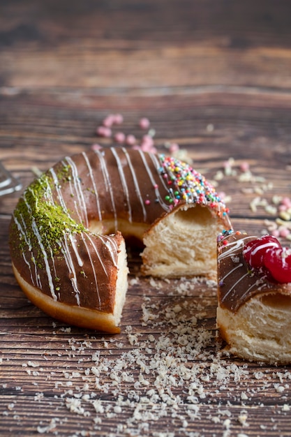 木製の背景の上に横たわっている1つのおいしい新鮮なチョコレートにかまれたドーナツ。