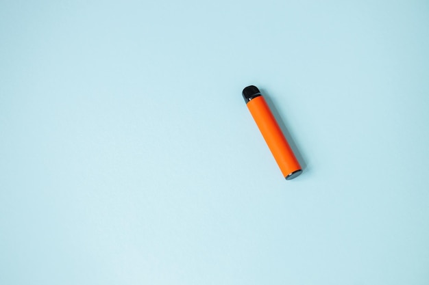 1つの使い捨てオレンジ色のタバコ悪い習慣の概念現代の喫煙電子タバコ