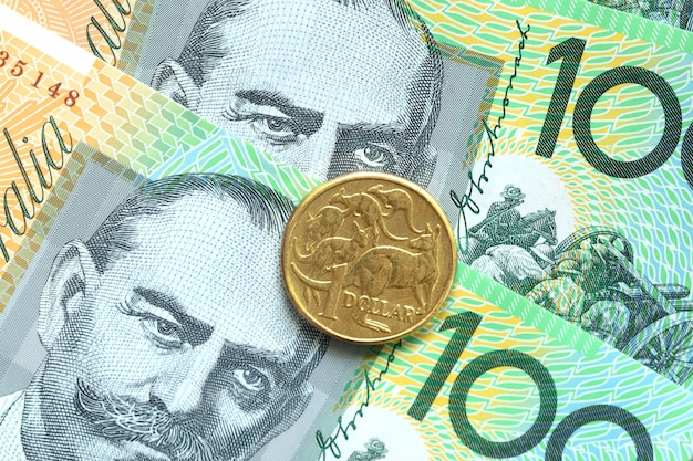 Monete australiane da un dollaro su un fondo di cento banconote