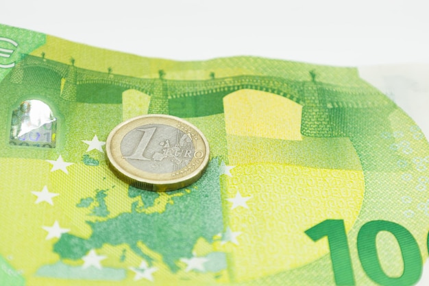 Foto una moneta da un euro su cento. banconota in euro