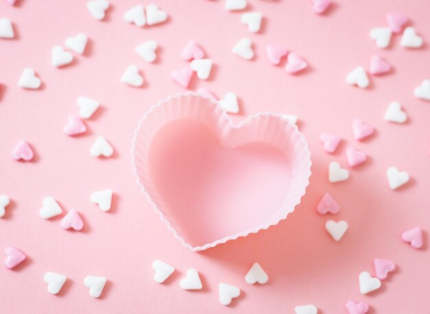 One form for a muffin heart with candy sprinkles on a pink background