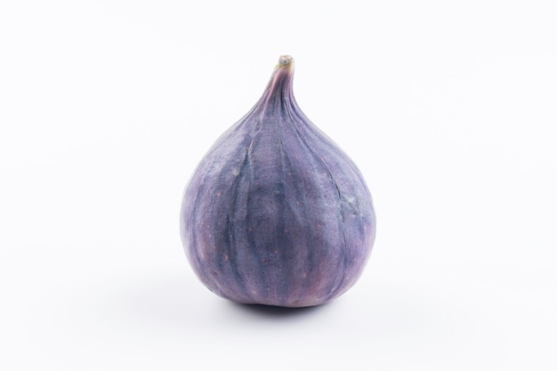 One fresh purple uncut raw fig isolated on white background