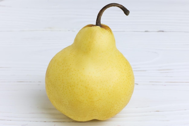 One fresh ripe organic yellow pear on a wooden white table Selective focus Closeup