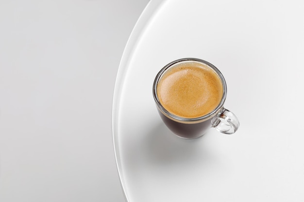 One glass coffee cup with espresso in morning on white table Mug of coffee Glass Close up top