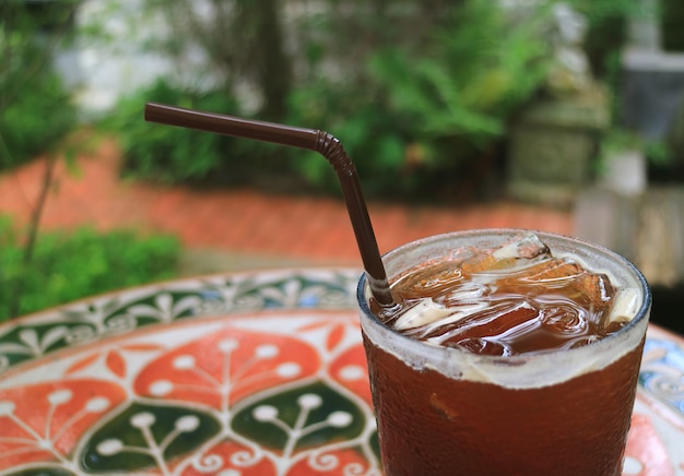 ぼやけて背景、ガーデンテラスのテーブルの上のアイスコーヒー