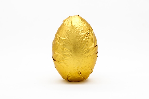 One golden egg  in crinkled metallic gold foil on white background.