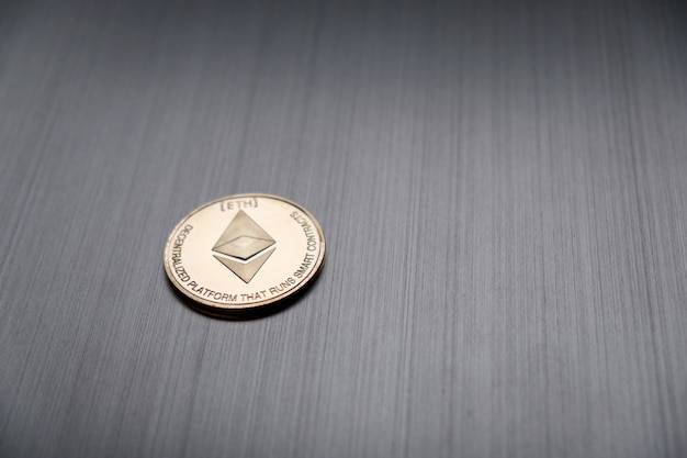 One golden ethereum coin on a metallic. Cryptocurrency and business financial concept.