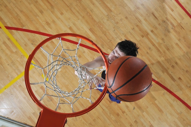 one healthy young  man play basketball game in school gym indoor