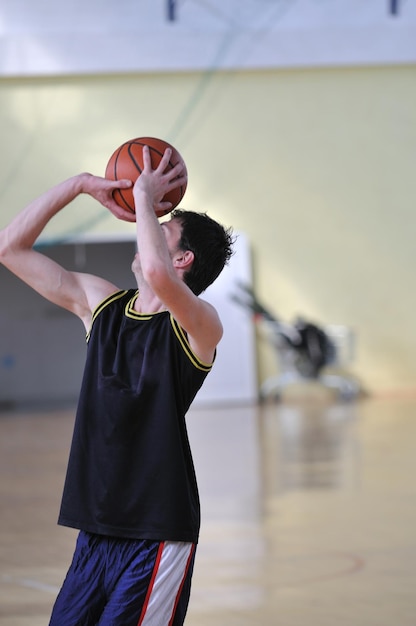 one healthy young  man play basketball game in school gym indoor