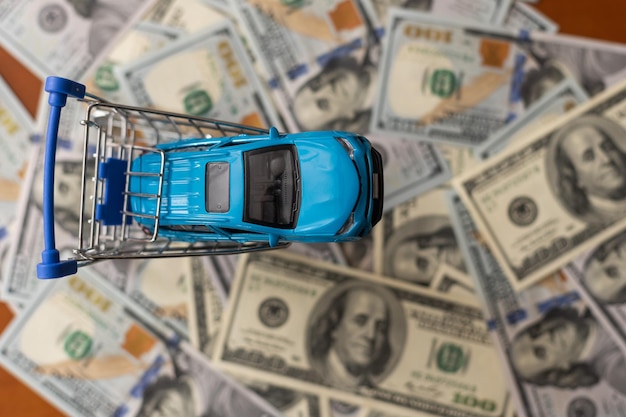 Photo one hundred dollar banknotes with small, toy car.