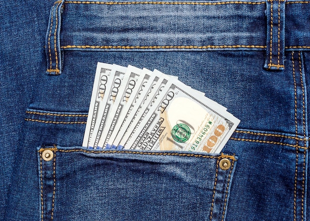 Banconote da cento dollari sulla tasca posteriore dei jeans